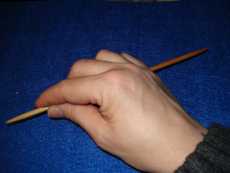 … die Stricknadel in die rechte Hand nehmen (beim Linkshänder vermutlich umgekehrt), so dass die Spitze zwischen Daumen und Zeigefinger genommen werden kann...